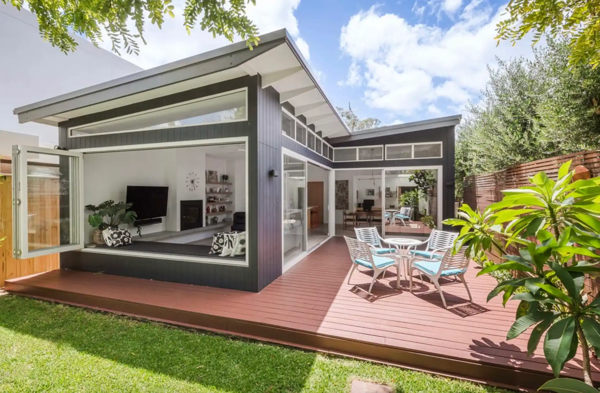 Modern Australian home with timber deck and open bifold doors — investment property